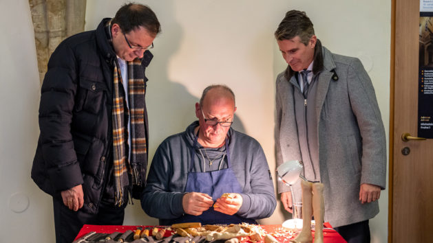 Staatsminister Eric Beißwenger (rechts) und Staatssekretär Martin Schöffel (links) schauten dem Holzbildhauermeister Norbert Tuffek (Mitte) über die Schultern.