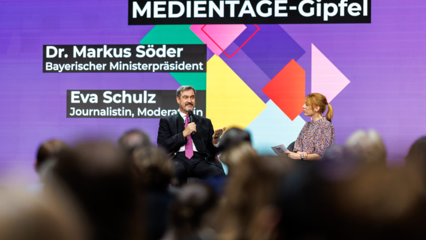 Ministerpräsident Dr. Markus Söder, links im Bild, auf dem Podium der Medientage München im Gespräch mit Moderatorin Eva Schulz.