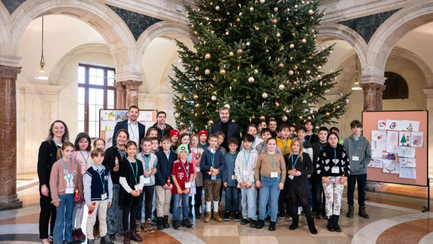 Gruppenbild mit Ministerpräsident Dr. Markus Söder und Schülerinnen und Schüler von der Grundschule Stöttwang und der Pfarrer-Huber-Schule Sonderpädagogisches Förderzentrum Landau an der Isar zur Übergabe von Weihnachtspostkarten im Kuppelsaal der Staatskanzlei.