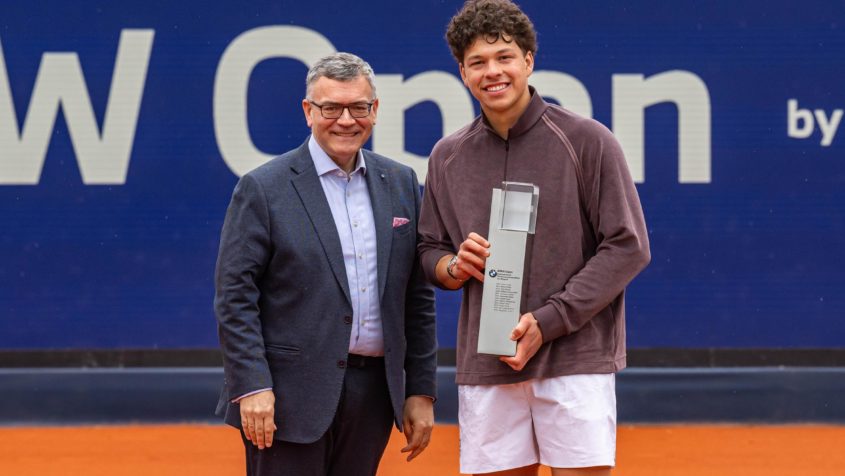 Staatsminister Dr. Florian Herrmann überreicht Ben Shelton den Siegerpokal.