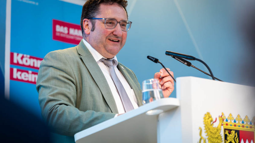 Gotthardt hält eine Begrüßungsrede am Rednerpult.